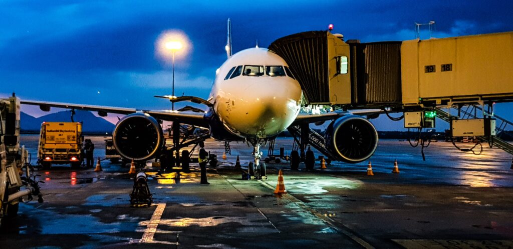 ein flugzeug steht bei nacht am flughafen und wird mit gepäck geladen