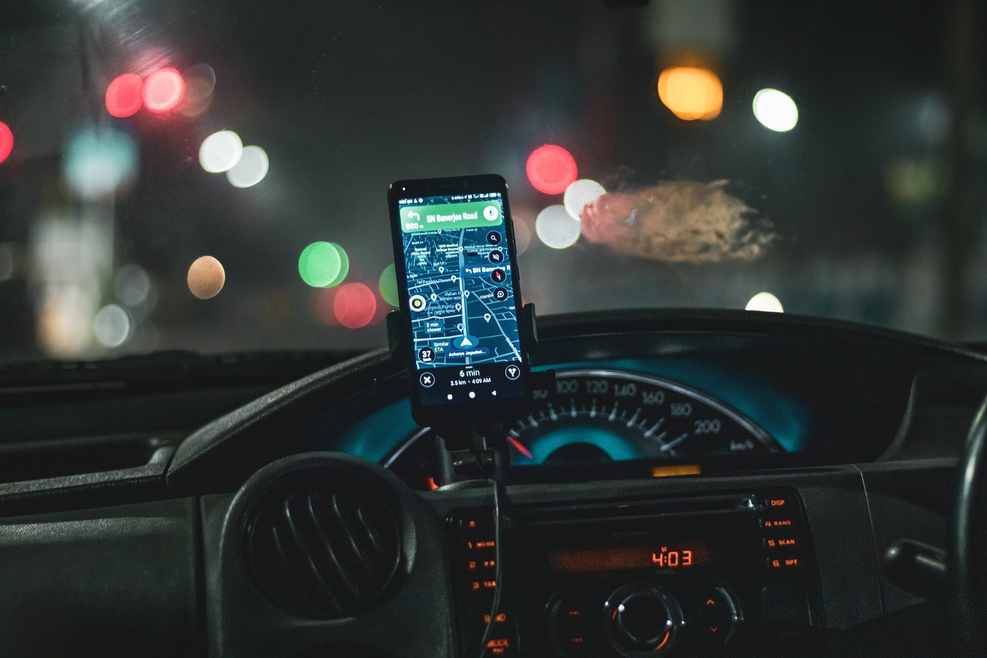 ein smartphone steckt in einer halterung in einem auto und hat eine navigationsapp geöffnet