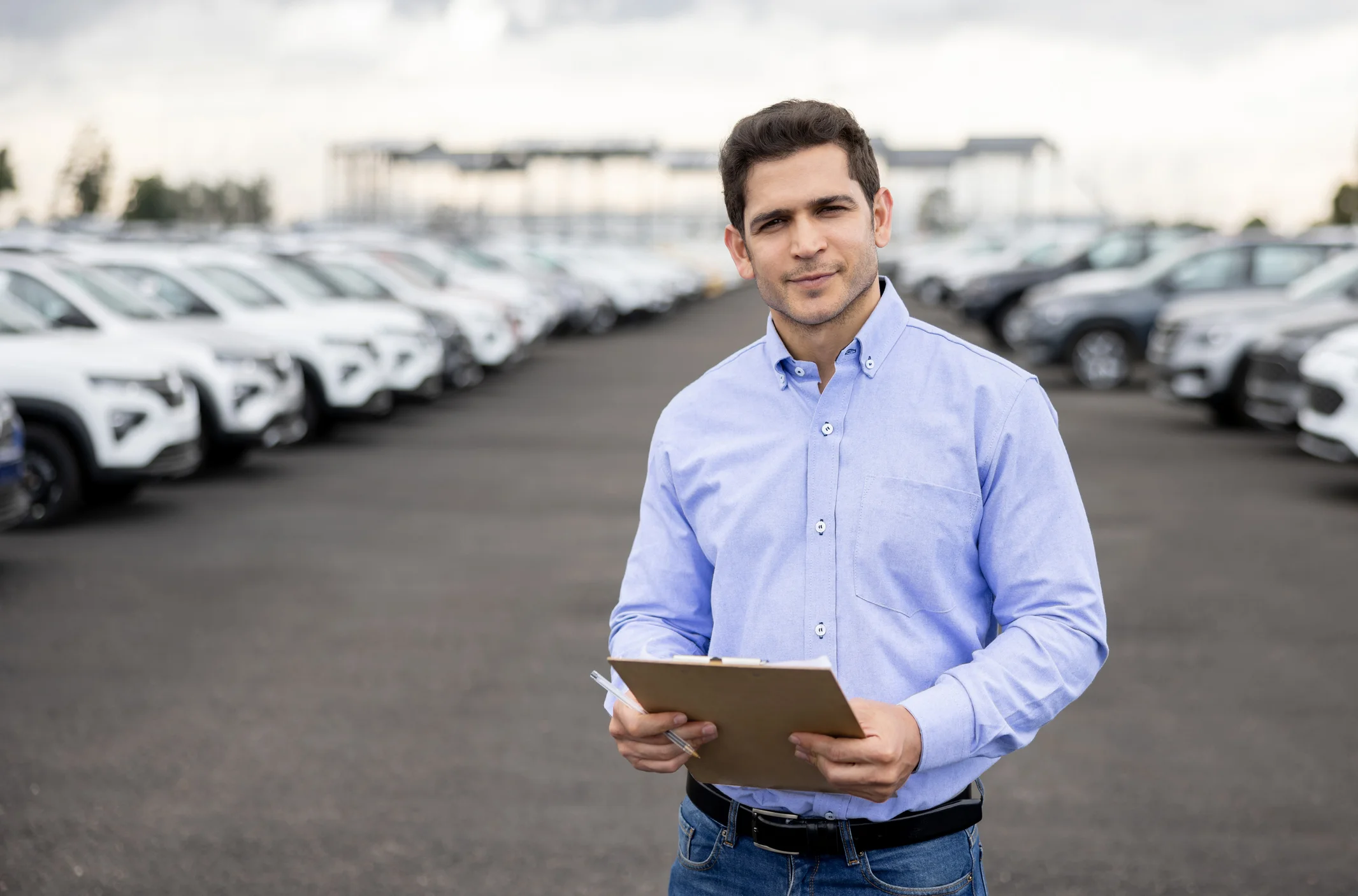 ein junger geschäftsmann steht auf einem auto fuhrpark