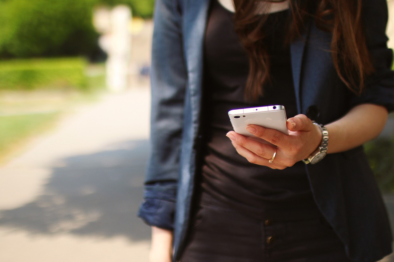 eine junge frau mit einem smartphone in der hand