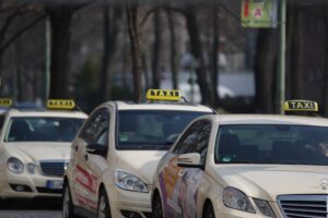 4 taxis stehen in einer reihe an einem taxistand und warten auf fahrgäste
